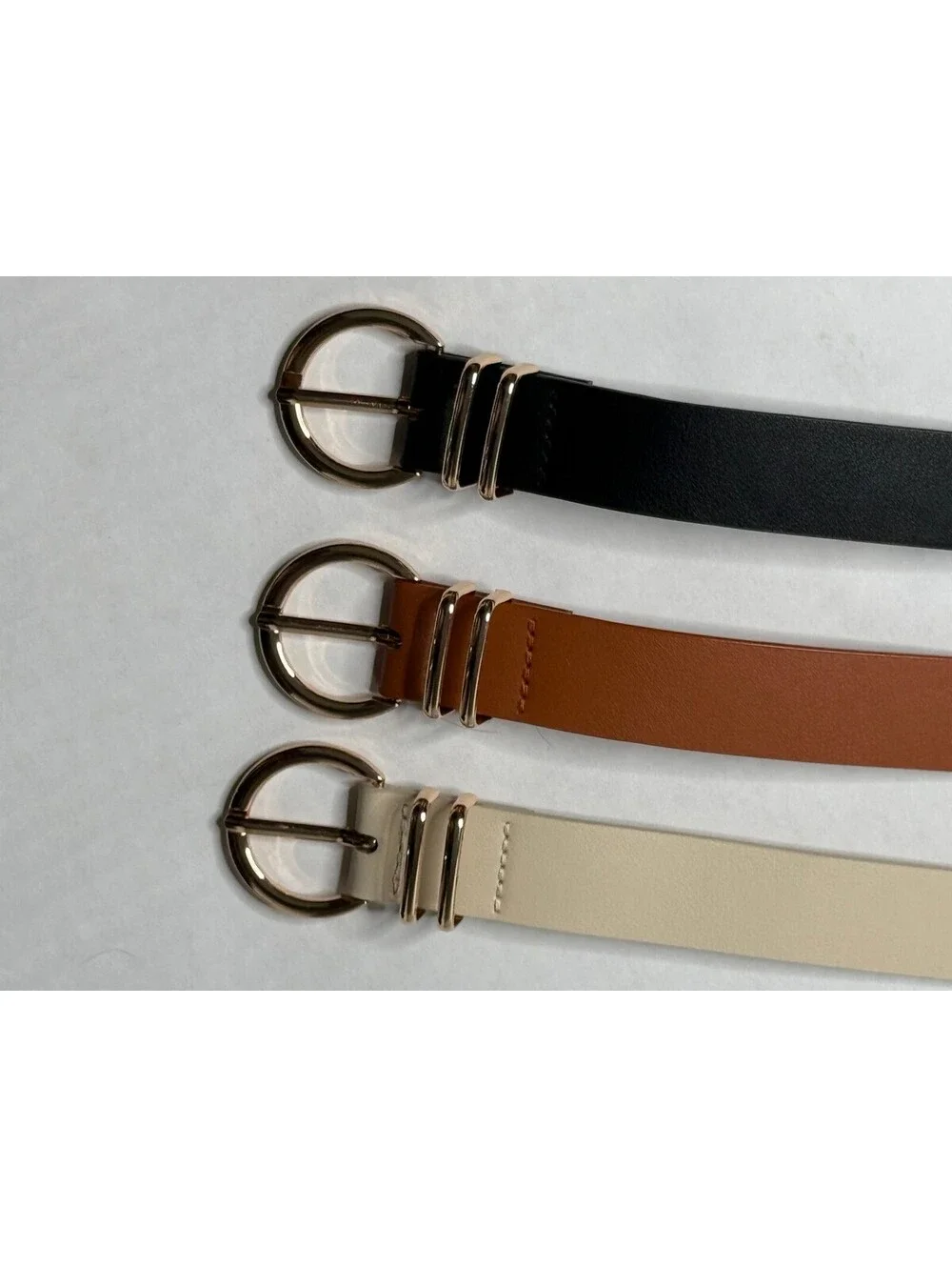 Women's Set of 3 Gold Buckle Accented Belts in Black, Brown and Cream.